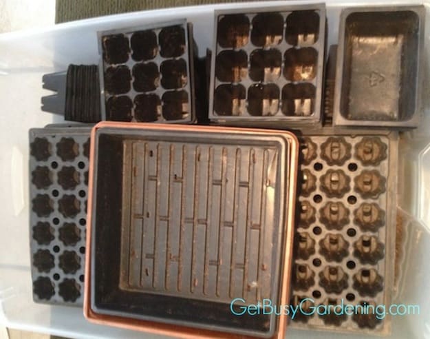A bin of old dirty used seed trays and inserts