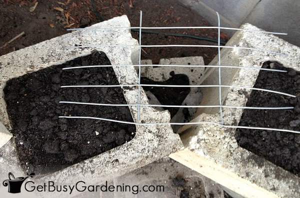 Wire support over curved planter block corner to hold the soil in