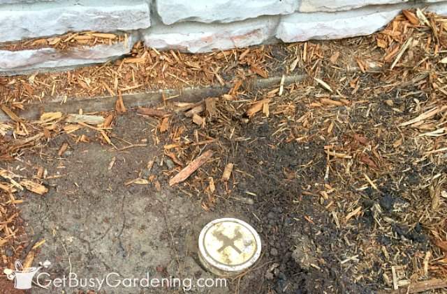 Pipe hidden under soil near house foundation