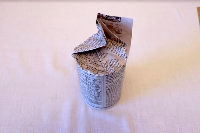 Newspaper folded around the bottom of the can Newspaper folded around the bottom of the can