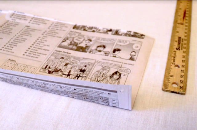 Creasing the strip of newspaper Creasing the strip of newspaper