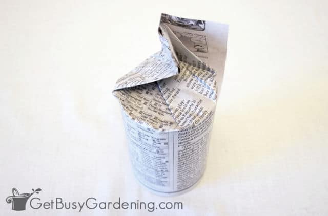 Newspaper folded around the bottom of a can