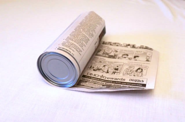 Rolling the newspaper around an aluminum can Rolling the newspaper around an aluminum can
