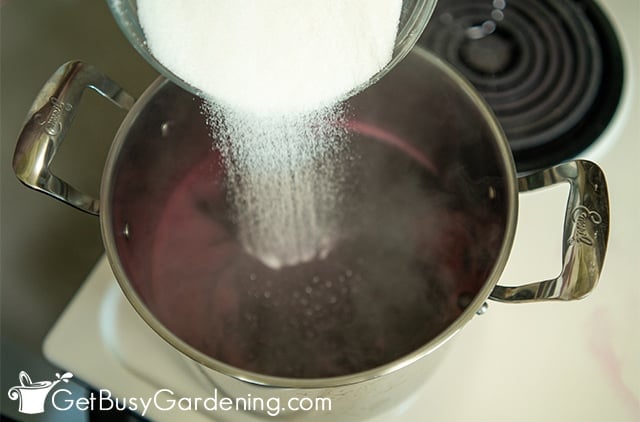 Adding sugar to grape juice to make jelly