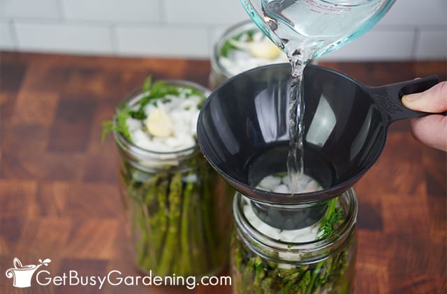 Pouring pickling brine over the asparagus