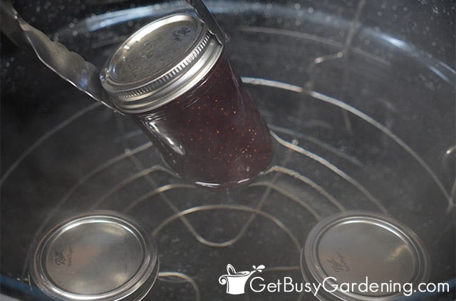Removing jars of strawberry jam from the canner