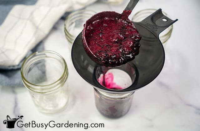Filling canning jars with blueberry jam