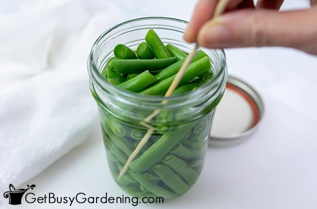Popping air bubbles in a jar of green beans