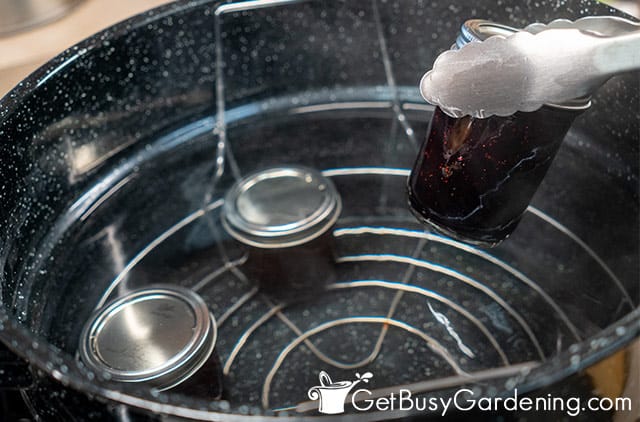 Removing jars of blueberry jam from the canner