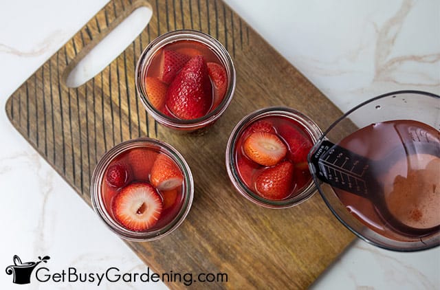 Filling canning jars with strawberries