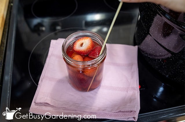 Popping air bubbles in a jar of strawberries