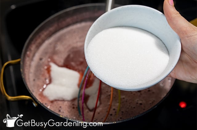 Adding sugar to thicken strawberry juice into jelly