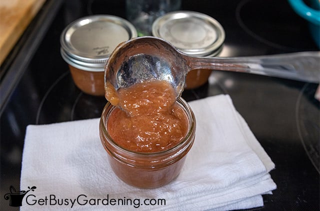 Filling canning jars with rhubarb jam