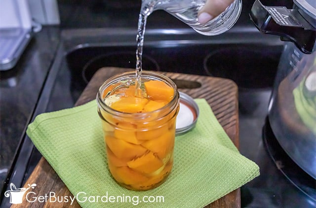 Pouring boiling water into jars of squash