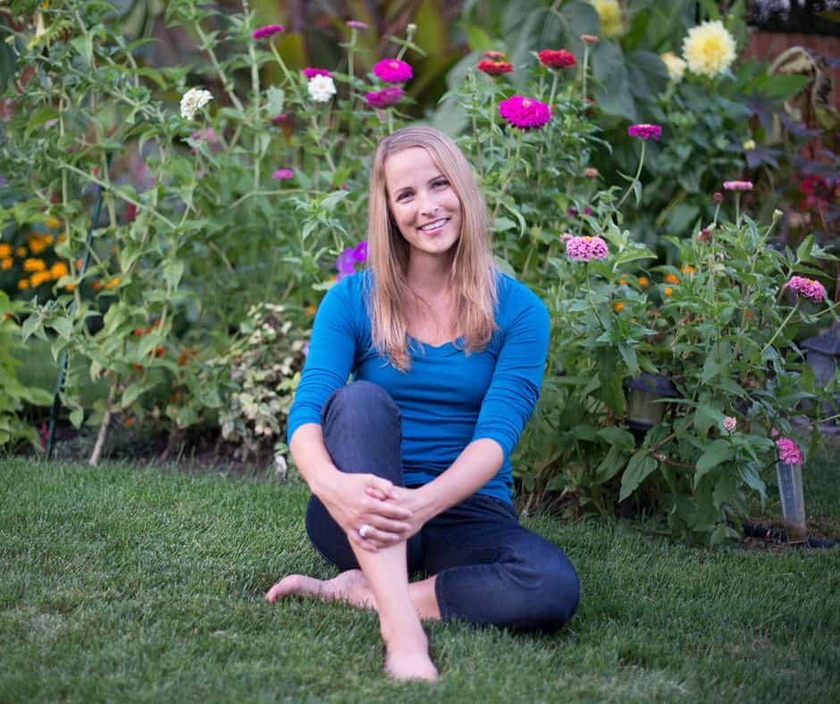 Picture of Amy Andrychowicz in front of her flower garden.